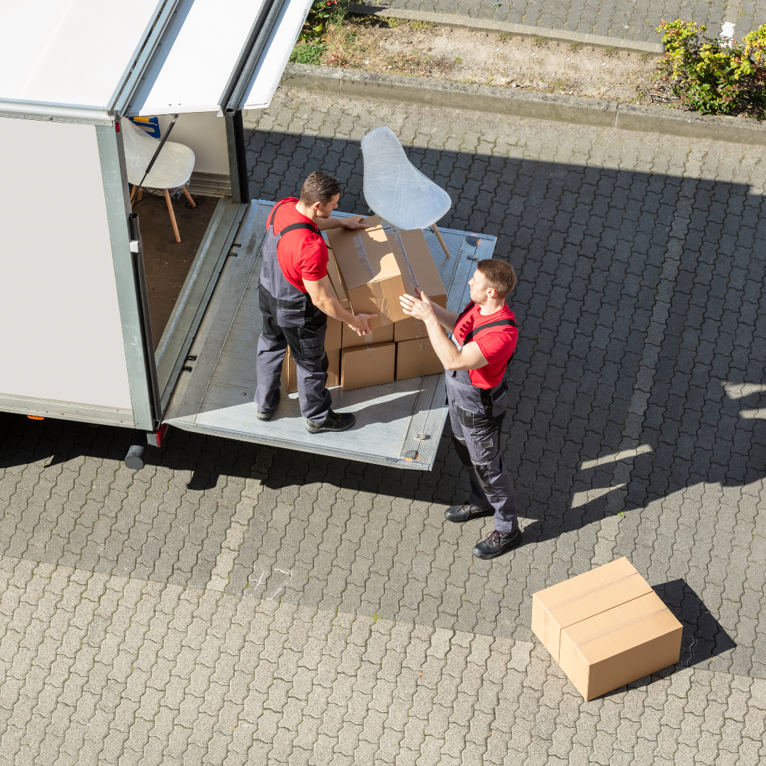 Moving to a New Province of two movers loading boxes and furniture into a moving truck.